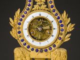 a gold clock with blue and white decorations on it