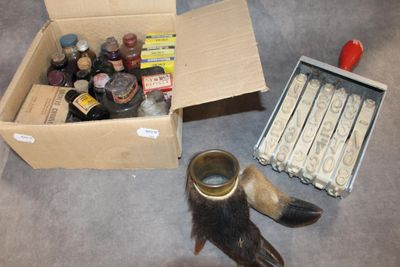 a box of assorted items on the floor next to a bird ' s foot