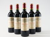 six bottles of wine are lined up in a row on a white surface