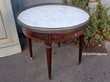 a small table with a marble top on a sidewalk