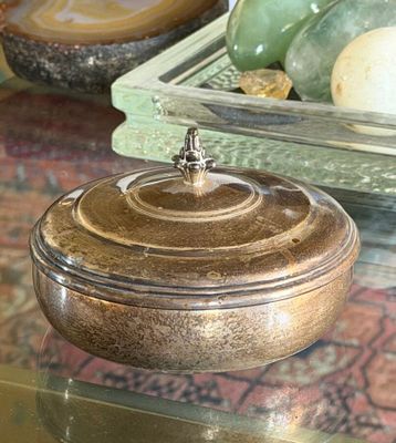 a glass bowl with a lid sitting on a glass table