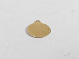 a small gold disc charm on a white surface