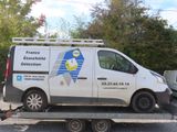 a white van that is on the back of a flatbed trailer