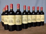 six bottles of red wine are lined up on a wooden table