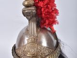 a silver helmet with a red feather on top of it
