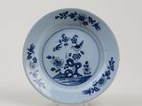 a blue and white plate with flowers and birds on it