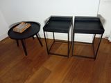 two black tables with trays on them in a room