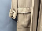 une photo d'un manteau beige accroché à un mur