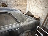 an old car that is sitting in a garage