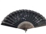 a black fan with flowers on it on a white background