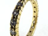 a close up of a gold ring with black diamonds on it