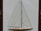 a framed picture of a sailboat on display in a frame