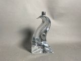 a glass sculpture of a bird on a table