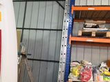 une camionnette blanche garée dans un garage dont les étagères sont remplies d'objets