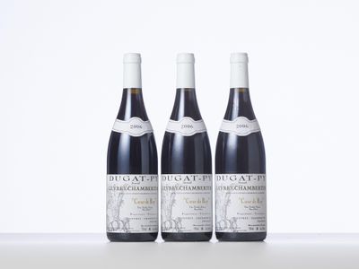 three bottles of wine are lined up on a table