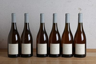 six bottles of wine are lined up on a wooden table
