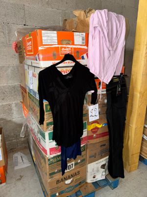 une pile de cartons recouverts de vêtements dans une pièce