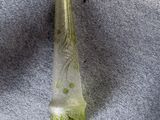 une bouteille en verre verte ornée d'un motif vert