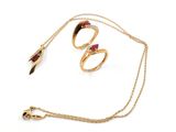 a close up of a gold necklace and a pair of rings on a chain