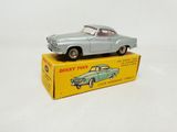 an old toy car sitting on top of a box on a white surface