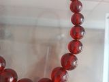 a close up of a red bead necklace on display