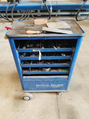 un chariot à outils bleu, chargé d'outils, dans un garage