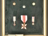 une photo montrant une médaille encadrée ainsi que d'autres objets