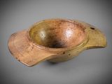an old wooden bowl with a wooden handle on a gray surface
