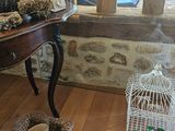 a small table with a birdcage and a bird on it