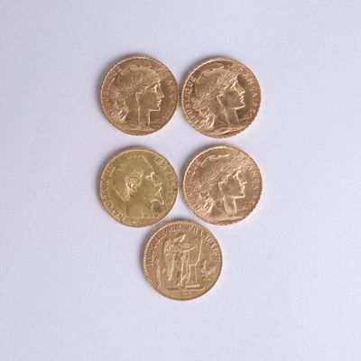 four different types of gold coins on a white surface
