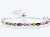 a close up of a bracelet with multi colored stones on a white background
