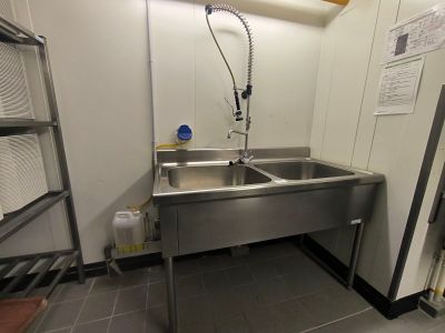 un évier en acier inoxydable dans le coin d'une pièce