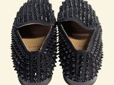 a pair of black spiked shoes on a white background