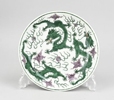 assiette verte et blanche ornée d'un motif représentant un dragon