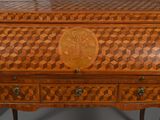 a wooden desk with a carved top and drawers