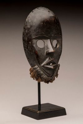 image d'un masque en bois sur un support sur fond blanc