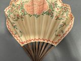 an old fan with writing on it hanging on the wall