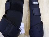 two pairs of knee pads on a wooden floor with a tag