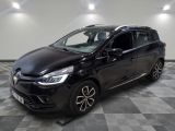 La voiture noire est garée sur un sol en carrelage à damier.
