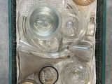 un panier vert rempli d'objets en verre posé par terre