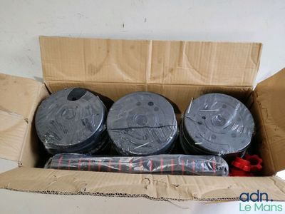quatre rouleaux de ruban adhésif dans une boîte en carton posée sur une table