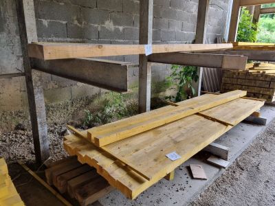 Plusieurs morceaux de bois sont empilés sur une palette à l'intérieur d'un bâtiment