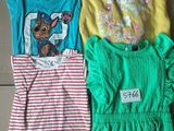 three children ' s t - shirts are sitting on the floor