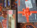 boxes of pens and pencils on a carpet with a red bow