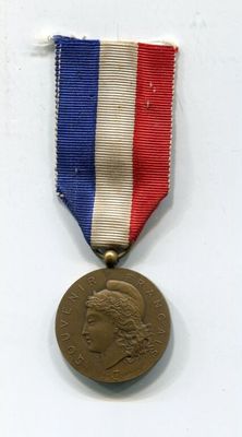 une vieille médaille entourée d'un ruban rouge, blanc et bleu