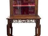 une vieille vitrine en bois surmontée d'une porte vitrée