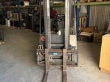 a forklift in a warehouse with a lot of boxes