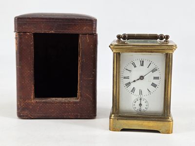 a small clock sitting next to a box on a table