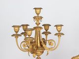 a gold colored chandelier that is next to a mirror