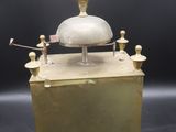 an old brass clock with a bell on top of it